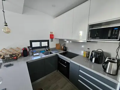 a kitchen with white cabinets and a black counter top at São Cristóvão AL in Boaventura
