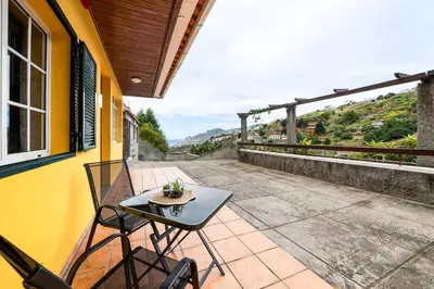 a patio with a table and chairs on a balcony at Sol Poente by GALMI in Funchal