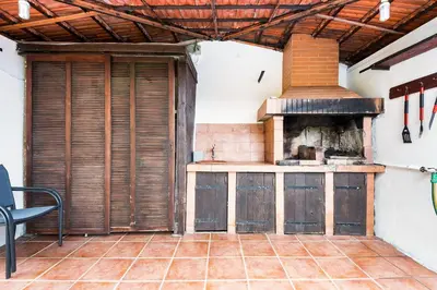 an outdoor kitchen with an oven in a room at Sol Poente by GALMI in Funchal