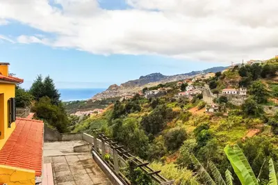 a view of a hill with houses and the ocean at Sol Poente by GALMI in Funchal