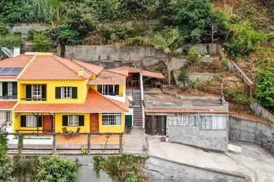 a yellow house with an orange roof on a hill at Sol Poente by GALMI in Funchal