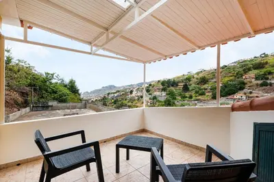 a balcony with two chairs and a table at Sol Poente by GALMI in Funchal