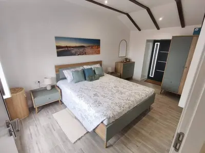 a bedroom with a large bed with blue pillows at Alojamiento Local - Estrela do Norte in Seixal