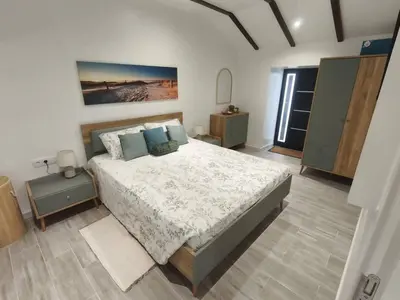 a bedroom with a large bed with blue pillows at Alojamiento Local - Estrela do Norte in Seixal