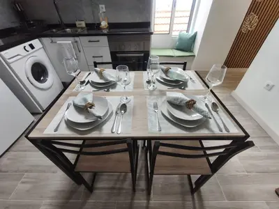 a kitchen and a living room with a table with chairs at Alojamiento Local - Estrela do Norte in Seixal