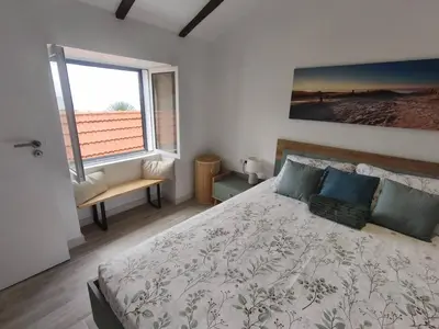 a bedroom with a large bed and a window at Alojamiento Local - Estrela do Norte in Seixal