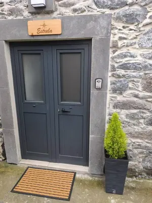 a blue door with a plant in front of a building at Alojamiento Local - Estrela in Seixal