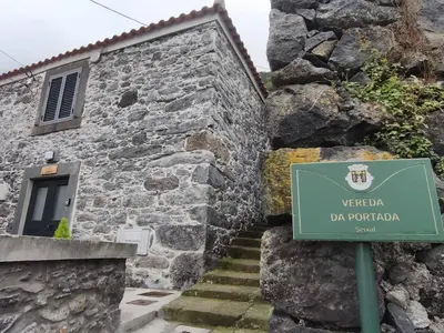 a stone building with a sign in front of it at Alojamiento Local - Estrela in Seixal