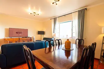 a living room with a table and a blue couch at GuestReady - Sea-View Retreat in Madeira in Funchal