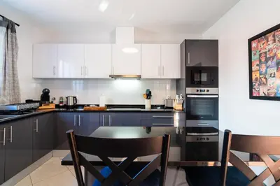 a kitchen with white cabinets and a table and chairs at GuestReady - Sea-View Retreat in Madeira in Funchal