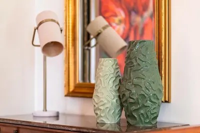 two green vases sitting on a table next to a lamp at GuestReady - Sea-View Retreat in Madeira in Funchal