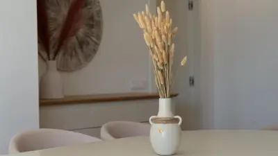 a white vase with flowers in it on a table at Acqua Sensation Suites by LovelyStay in Funchal