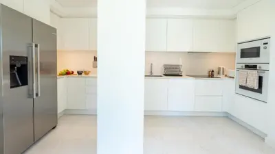 a kitchen with white cabinets and a stainless steel refrigerator at Acqua Sensation Suites by LovelyStay in Funchal