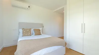 a bedroom with a bed with white walls at Acqua Sensation Suites by LovelyStay in Funchal