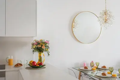 a white kitchen with a vase of flowers and a mirror at Madeira Aqua Dream in Funchal