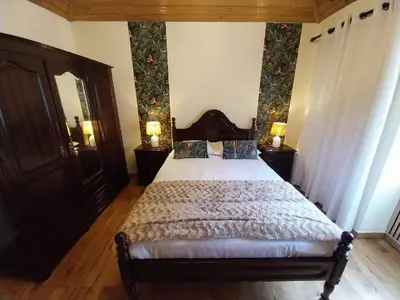 a bedroom with a bed and a dresser and a mirror at Casa da Guiomarinha in Seixal