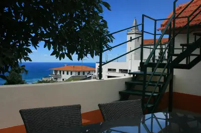 a patio with a couch and a table and a stone wall at Casa da Guiomarinha in Seixal