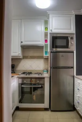a kitchen with white cabinets and a stainless steel refrigerator at Monumental Apartment in Funchal