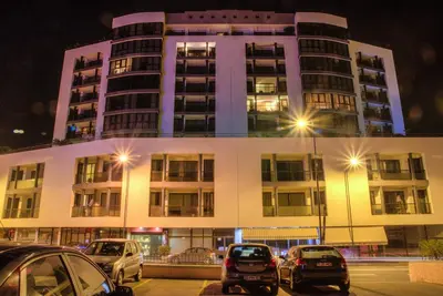 a parking lot with cars parked in front of a building at Monumental Apartment in Funchal