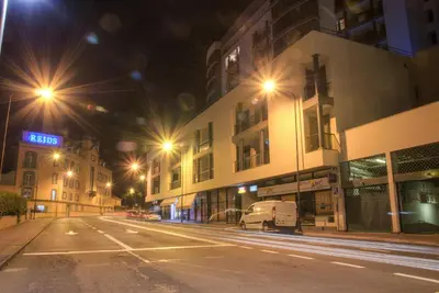 an empty city street at night with street lights at Monumental Apartment in Funchal