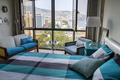 a bedroom with a bed and a view of a city at Monumental Apartment in Funchal