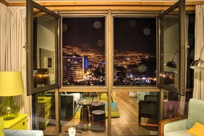 a room with a large window with a view of a city at Monumental Apartment in Funchal