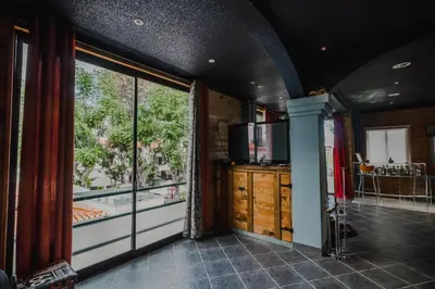 a room with a large window and a television at The Modern & Recycled House in Machico