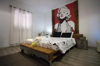 a bedroom with a bed with a painting on the wall at The Modern & Recycled House in Machico