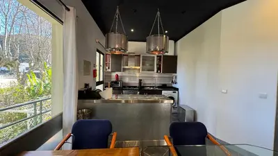 a kitchen with a table and two blue chairs at The Modern & Recycled House in Machico