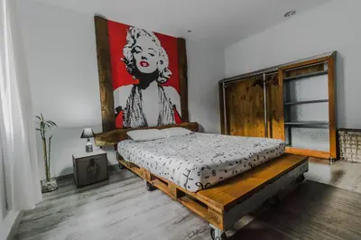 a bedroom with a bed with a painting on the wall at The Modern & Recycled House in Machico