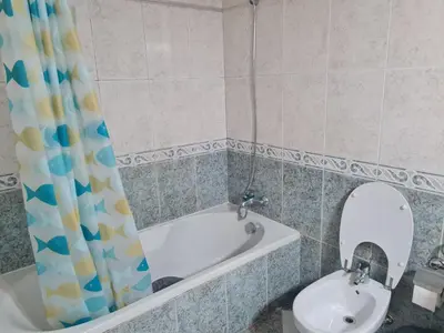 a bathroom with a tub and a sink and a mirror at Geovanny house in Funchal