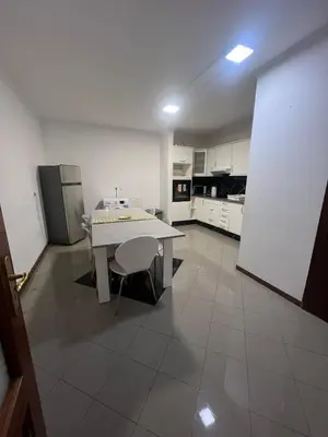 a kitchen with a white table and a refrigerator at Geovanny house in Funchal