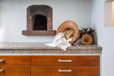a counter with a basket and a brick oven at Casa Graminho in Ponta do Sol