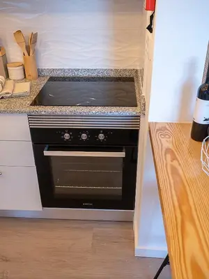 a kitchen with a black stove in a kitchen at Traditional Madeira House Garden, Terrace & BBQ in Ribeira Brava