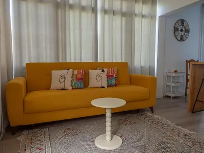 a living room with a yellow couch and a table at Traditional Madeira House Garden, Terrace & BBQ in Ribeira Brava