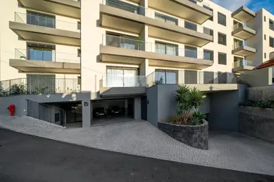 a building with a red fire hydrant in front of it at Saraiva Hills II by An Island Apart in Câmara de Lobos
