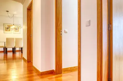 a hallway with wooden doors and a dining room at Alzira's Place, a Home in Madeira in Ponta do Sol