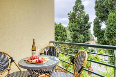 a table with a plate of fruit and a bottle of wine at Alzira's Place, a Home in Madeira in Ponta do Sol