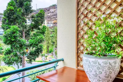 a vase sitting on a table on a balcony at Alzira's Place, a Home in Madeira in Ponta do Sol