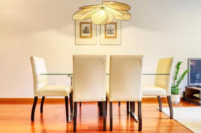 a dining room table with four chairs and a chandelier at Alzira's Place, a Home in Madeira in Ponta do Sol
