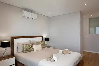 a white bedroom with two beds with towels on them at Villa Joy, moderna e sofisticada in Funchal