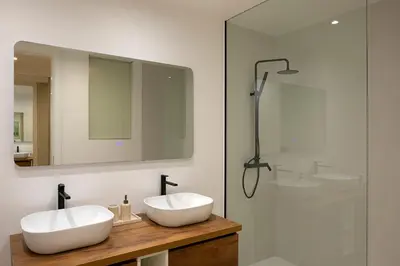 a bathroom with two white sinks and a shower at Villa Joy, moderna e sofisticada in Funchal