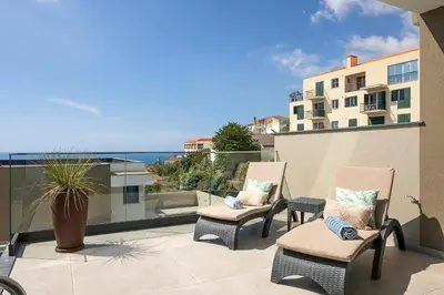 two chairs on a balcony with a view of the ocean at Villa Joy, moderna e sofisticada in Funchal