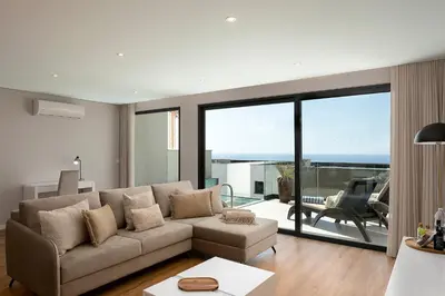 a living room with a couch and a view of the ocean at Villa Joy, moderna e sofisticada in Funchal