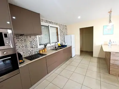 a kitchen with a table and a dining room at La Maison Dorée in Porto Santo