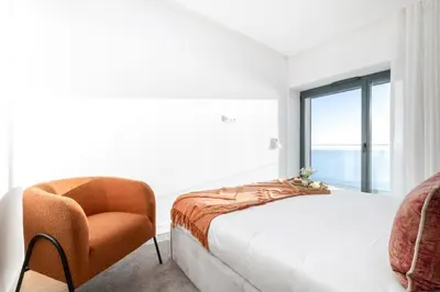 a bedroom with a large bed with a large window at Madeira Acqua Residence in Funchal