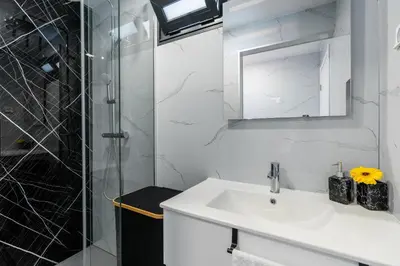a white bathroom with a sink and a shower at Casa do Paulinhos - Vista Panorâmica, Natureza, Wi-Fi Rápido in Estreito da Calheta