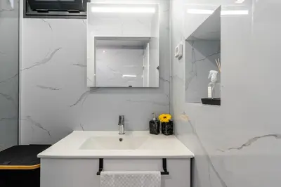 a white bathroom with a sink and a mirror at Casa do Paulinhos - Vista Panorâmica, Natureza, Wi-Fi Rápido in Estreito da Calheta
