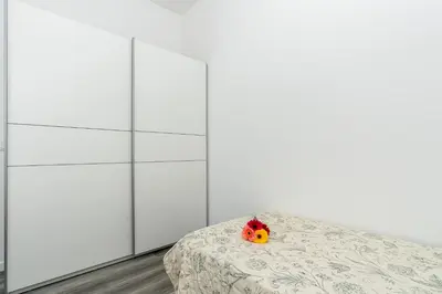 a bedroom with white wardrobes and a bed with a flower on it at Casa do Paulinhos - Vista Panorâmica, Natureza, Wi-Fi Rápido in Estreito da Calheta