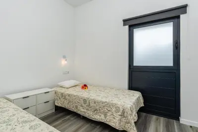 a bedroom with two beds and a window at Casa do Paulinhos - Vista Panorâmica, Natureza, Wi-Fi Rápido in Estreito da Calheta